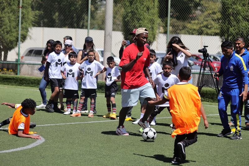 Moisés Caicedo jugando fútbol con niños de escasos recursos