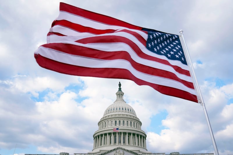 Archivo - Una bandera de Estados Unidos ondea frente el Capitolio el 6 de febrero de 2023, en Washington. Estados Unidos está a punto de iniciar la cuenta regresiva para celebrar su 250 aniversario. (AP Foto/Mariam Zuhaib, Archivo)