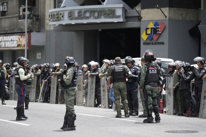 La policía y la Guardia Nacional se encuentran afuera del Consejo Nacional Electoral (CNE) el día después de las elecciones presidenciales