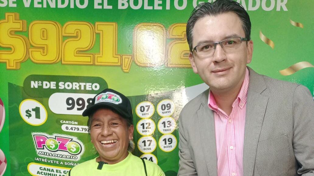Ronald Trujillo, jefe de ventas Lotería Nacional - Riobamba, entregó varios premios simbólicos a doña América Criollo, quien vendió el boleto ganador del Pozo Millonario.