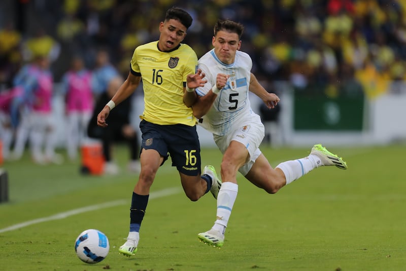 Kendry Páez disputa el balón con Manuel Ugarte Ribeiro de Uruguay  en un partido de las Eliminatorias Sudamericanas para la Copa Mundial de Fútbol 2026