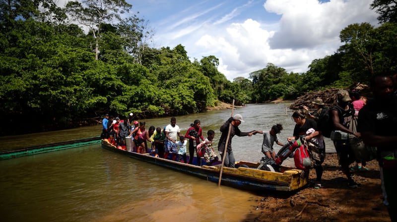 Migrantes descienden de una canoa antes de llegar a la Estación de Recepción Migratoria (ERM) de Lajas Blancas, el 18 de diciembre de 2023, luego de atravesar la selva del Darién (Panamá)