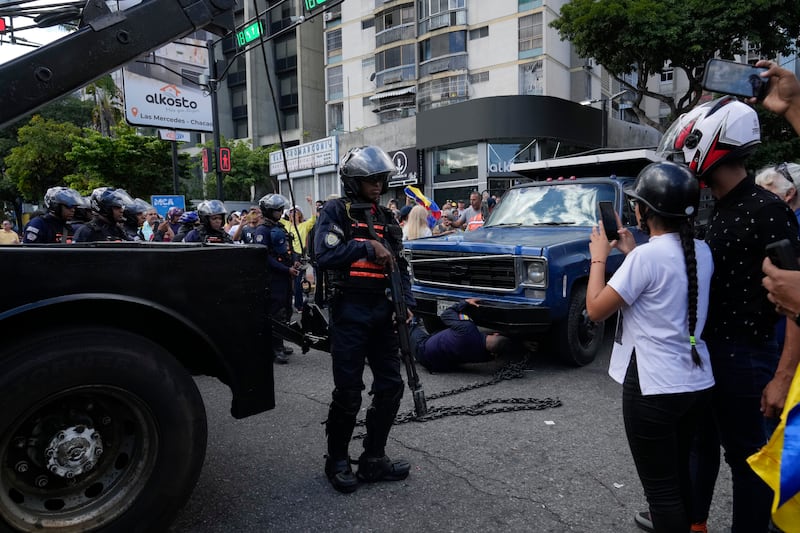 La policía toma posesión del camión desde el cual la líder opositora María Corina Machado se dirigió a sus partidarios en una protesta en Caracas, Venezuela, el jueves 9 de enero de 2025, el día antes de la toma de posesión del presidente Nicolás Maduro para un tercer mandato. (Foto AP/Ariana Cubillos)