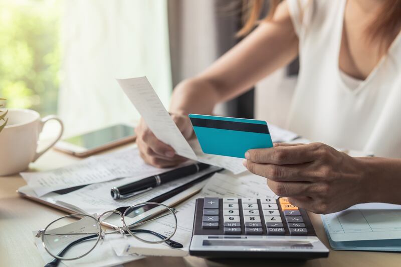 Joven revisando facturas, impuestos, saldo de cuenta bancaria y calculando gastos de tarjeta de crédito en casa