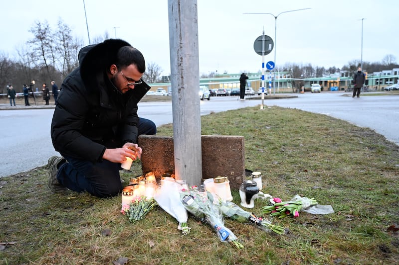 Un hombre enciende una vela en un monumento improvisado tras un tiroteo, frente a la escuela Risbergska en Orebro, Suecia, el 5 de febrero de 2025.