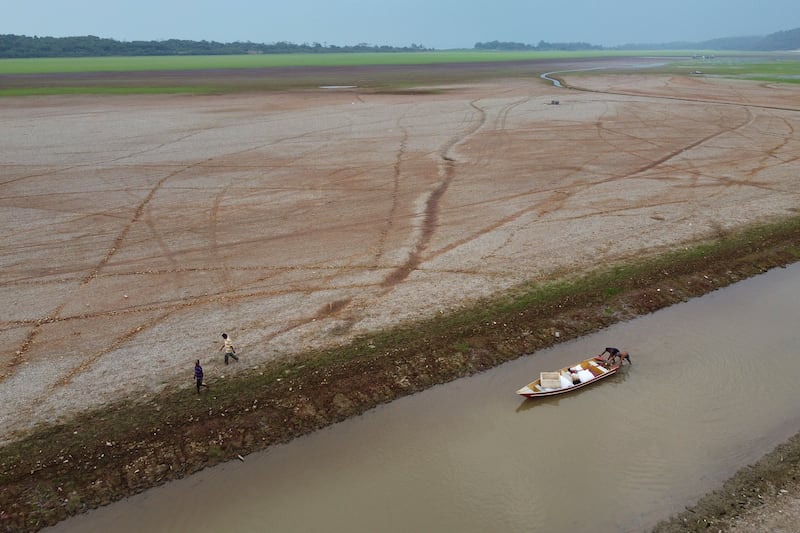 Pescadores empujan un bote en el lago Aleixo en medio de una sequía en Manaus, estado de Amazonas, Brasil, el 24 de septiembre de 2024.