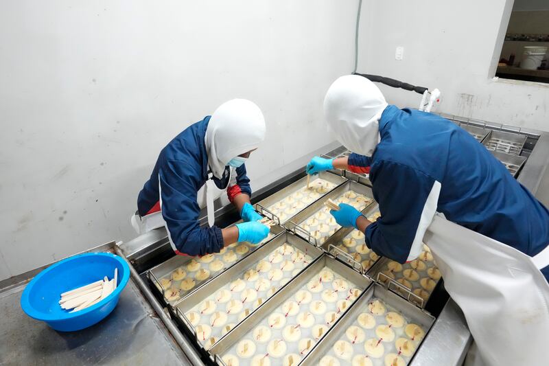 Trabajadores preparan helados en una fábrica artesanal en Salcedo, Ecuador, el jueves 28 de noviembre de 2024 en medio de una oleada de apagones provocados por un prolongado apagón. (AP Foto/Dolores Ochoa)